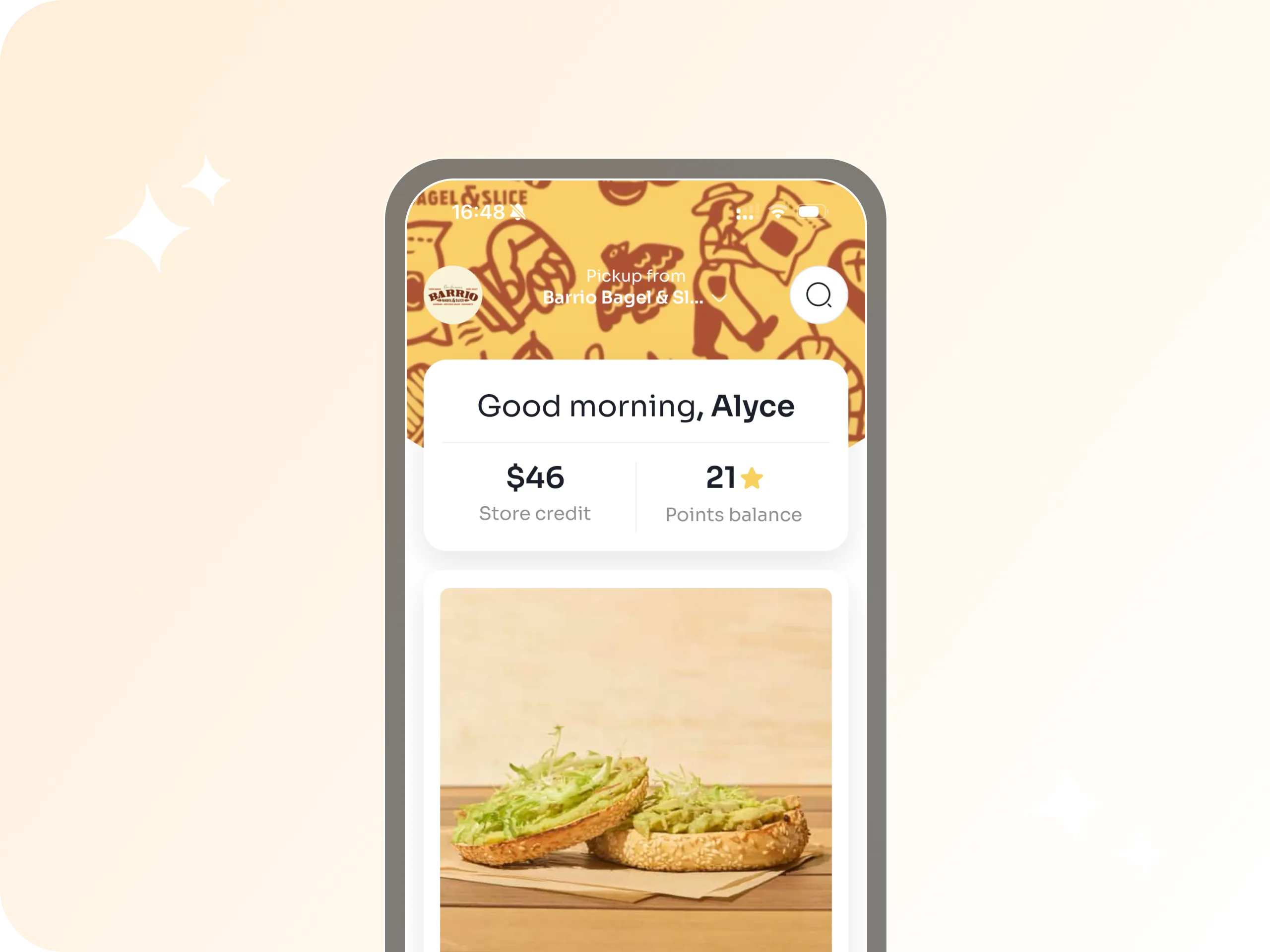 Mobile app screen showing greeting to user Alyce, $46 store credit, 21 points balance, and an image of a sesame bagel with avocado spread on a wooden table.